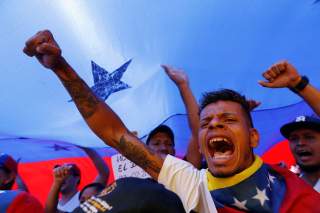 Supporters of the Venezuelan opposition leader Juan Guaido, who many nations have recognized as the country's rightful interim ruler, take part in a rally to demand President Nicolas Maduro to allow humanitarian aid to enter the country, in Caracas, Venez