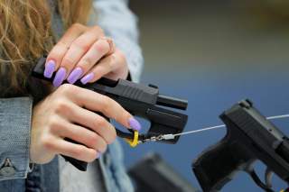 A woman handles a gun inside of the Sig Sauer booth during the National Rifle Association (NRA) annual meeting in Indianapolis, Indiana, U.S., April 28, 2019. REUTERS/Lucas Jackson