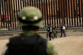 A National Guard soldier observes migrants after crossing illegally into El Paso, Texas, U.S. to turn themselves in to U.S. Border Patrol agents to ask for asylum, as seen from Ciudad Juarez, Mexico September 15, 2019. REUTERS/Jose Luis Gonzalez