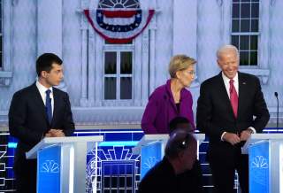 South Bend Mayor Pete Buttigieg looks on as Senator Elizabeth Warren and former Vice President Joe Biden talk during a break in the U.S. Democratic presidential candidates debate at the Tyler Perry Studios in Atlanta, Georgia, U.S. November 20, 2019.