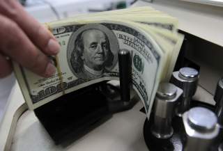 A bank employee counts U.S. hundred dollar bills at Kasikornbank in Bangkok October 12, 2010. The Thai government agreed on Tuesday to impose a 15 percent withholding tax on interest and capital gains earned by foreign investors on Thai bonds, the latest 