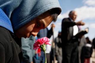 A boy holds a flower during the funeral of 16-year-old Karina Ivette Delgado in Ciudad Juarez February 3, 2011. Delgado was killed in a crossfire between suspected car thieves and federal agents on Sunday, according to local media.  REUTERS/Gael Gonzalez 