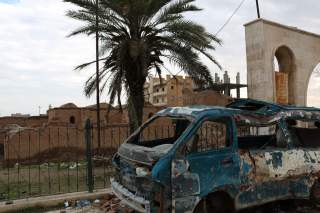 Image by Samuel Sweeney taken in Raqqa on December 11, 2018. A bombed van in front of Qasr al-Banat, a historic site in Raqqa dating to Harun al-Rashid's caliphate which also used Raqqa as its capital, from 796 to 809 AD. 