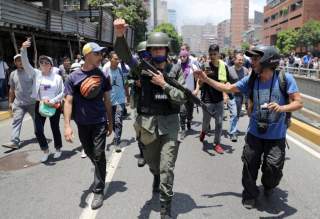 A Venezuelan National Guard member gestures, after joining anti-government protesters in a march, showing his support for opposition leader Juan Guaido in Caracas, Venezuela April 30, 2019. REUTERS/Manaure Quintero.