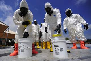 U.S. Soldiers from the 457th Chemical Battalion sponge off their level A protective suits after a simulated nuclear detonation scenario at the Muscatatuck Urban Training Center in Indiana July 19, 2010, during exercise Vibrant Response 10.2. 