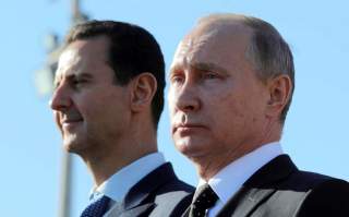 Russian President Vladimir Putin (R) and Syrian President Bashar al-Assad visit the Hmeymim air base in Latakia Province, Syria December 11. REUTERS/File Photo