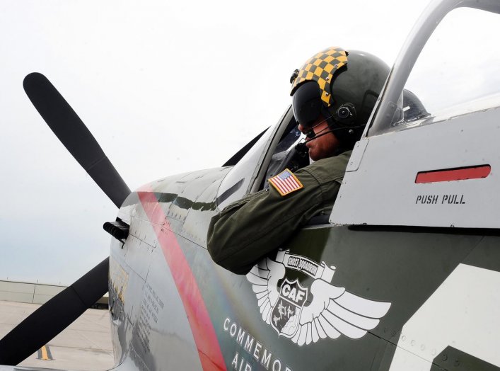 Larry Lumpkin, pilot of the P-51 Mustang, dons his helmet and flight suit for a media photo shoot at the Council Bluffs Municipal Airport, Iowa, on June 27. (U.S. Air Force photo by Josh Plueger)