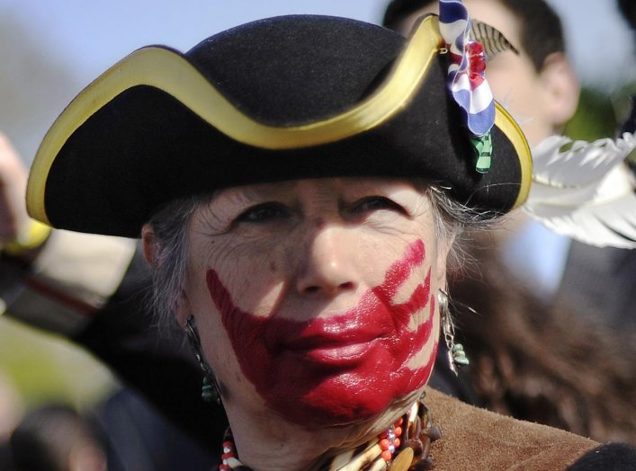 Tea party supporter Susan Clark of California, dressed in colonial garb and face paint, protests against the Obama healthcare legislation as the law's supporters and detractors rally on the sidewalk in front of the Supreme Court, during the third and fina