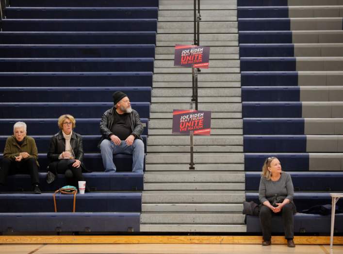 Posters for Democratic presidential candidate and former Vice President Joe Biden stand near voters waiting for a caucus to begin in Des Moines, Iowa, U.S., February 3, 2020. REUTERS/Brian Snyder