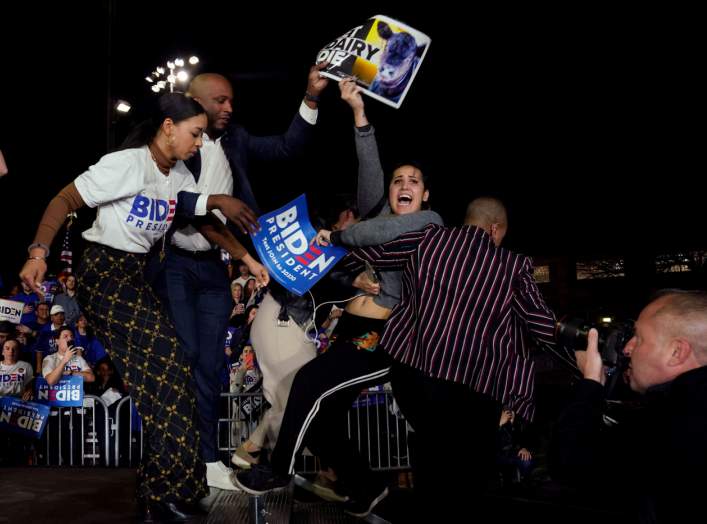 Anti-dairy industry protestors are pulled from the stage as Democratic U.S. presidential candidate and former Vice President Joe Biden speaks at his Super Tuesday night rally in Los Angeles, California, U.S., March 3, 2020. REUTERS/Kyle Grillot