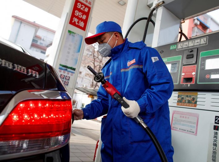 A pump attendant wears a mask as he refuels a car at a Sinopec gas station where customers can buy supplies as the country is hit by an outbreak of the novel coronavirus, in Beijing, China, February 28, 2020. REUTERS/Thomas Peter