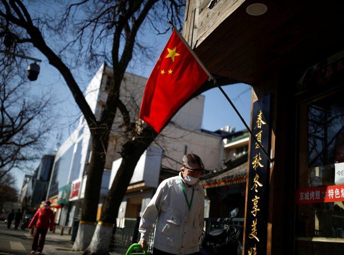 A man wearing a face masks walks on the street following an outbreak of the coronavirus disease (COVID-19), in Beijing, China March 27, 2020. REUTERS/Carlos Garcia Rawlins