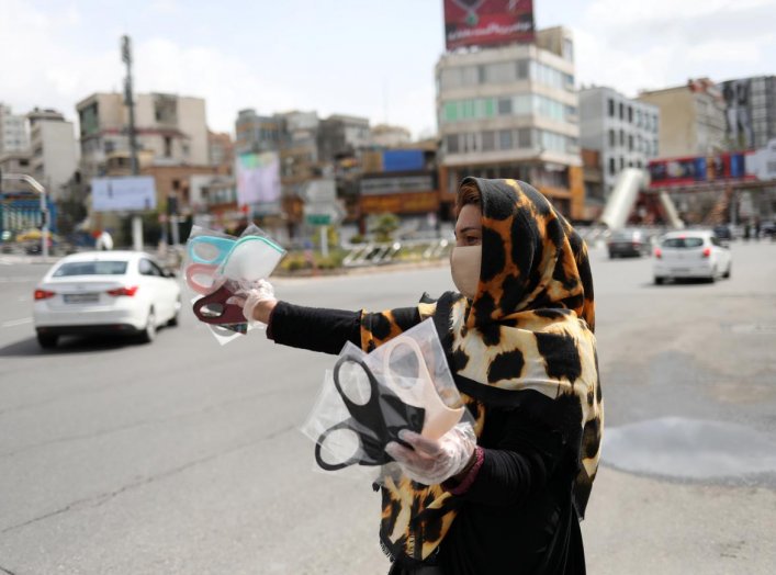 A woman wears a protective face mask and gloves, amid fear of the coronavirus disease (COVID-19), as she sells the masks in Tajrish square in Tehran, Iran April 2, 2020. WANA (West Asia News Agency)/Ali Khara via REUTERS