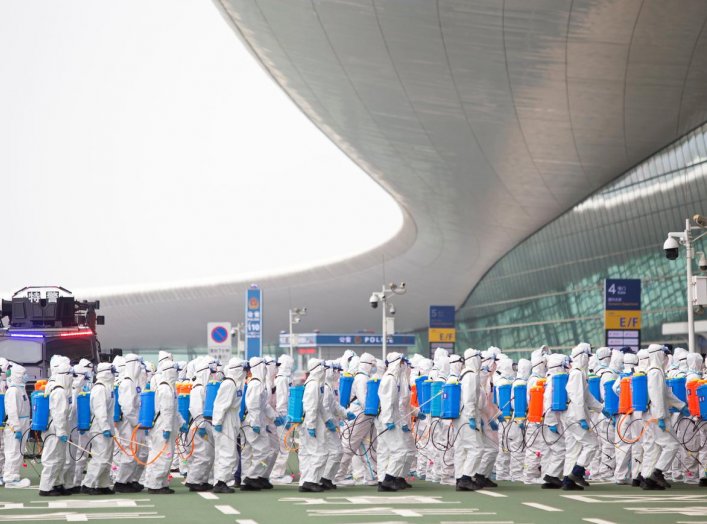 Firefighters in protective suits are seen during an operation to disinfect Wuhan Tianhe International Airport before the airport resumes its domestic flights on April 8, in Wuhan, Hubei province, the epicentre of China's novel coronavirus disease (COVID-1