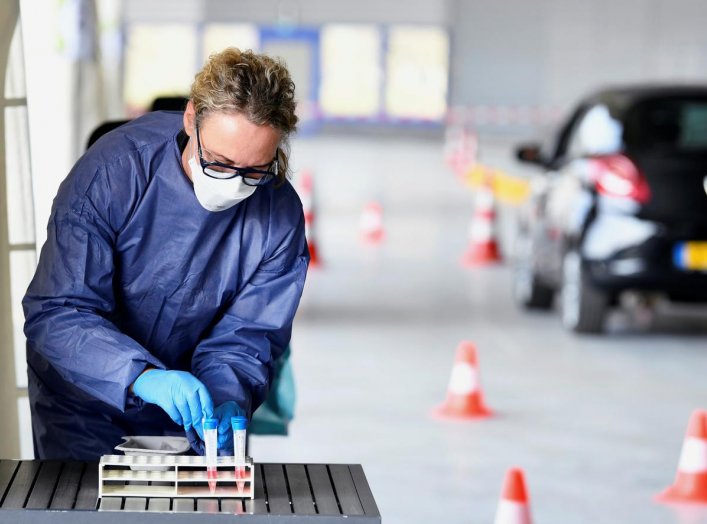 A member of medical staff takes coronavirus test samples during drive-thru coronavirus disease (COVID-19) testing, on a converted ice rink, in Alkmaar, Netherlands April 8, 2020. REUTERS/Piroschka van de Wouw