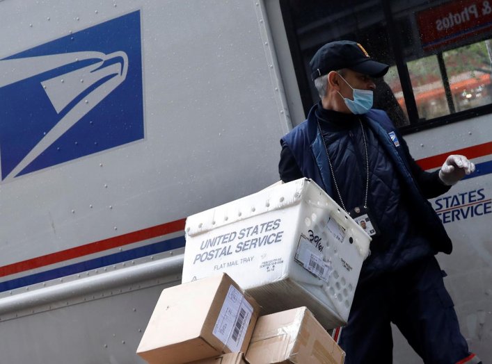 A United States Postal Service (USPS) worker unloads packages from his truck in Manhattan during the outbreak of the coronavirus disease (COVID-19) in New York City, New York, U.S., April 13, 2020. REUTERS/Mike Segar