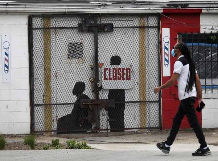 A pedestrian walks past a closed barber shop in Ward 7 as the coronavirus disease (COVID-19) outbreak continues in Washington, U.S., May 8, 2020. REUTERS/Leah Millis