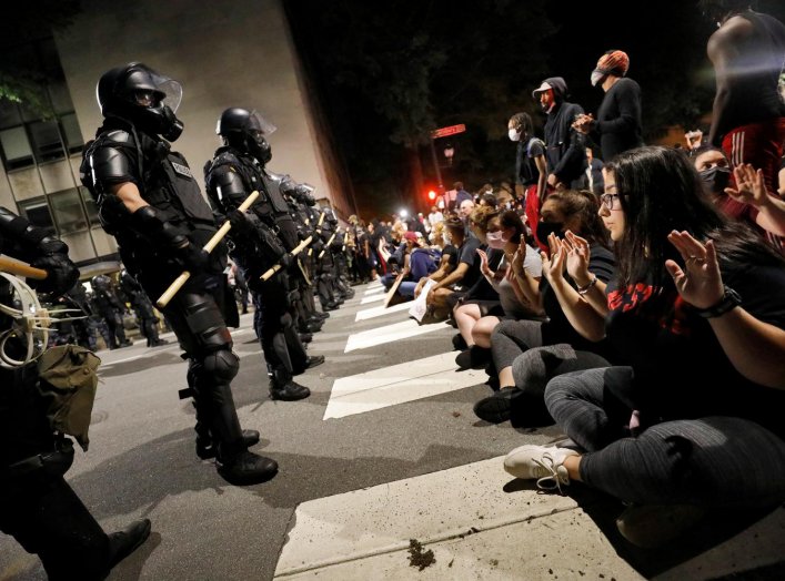 Protesters sit in the street facing a line of riot policemen during nationwide unrest following the death in Minneapolis police custody of George Floyd, in Raleigh, North Carolina, U.S. May 31, 2020. REUTERS/Jonathan Drake