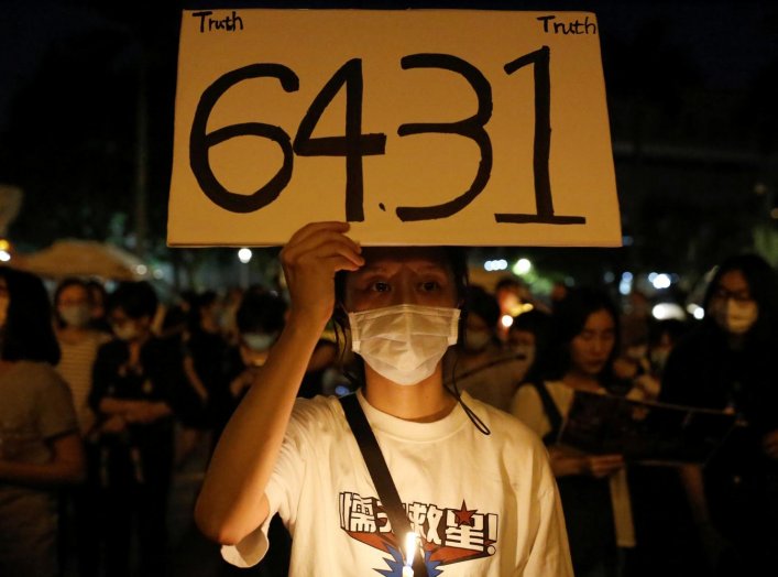 A man wearing a protective mask holds a placard at Liberty Square in Taipei to mark the 31st anniversary of the crackdown of pro-democracy protests at Beijing's Tiananmen Square in 1989, Taiwan, June 4, 2020. REUTERS/Ann Wang