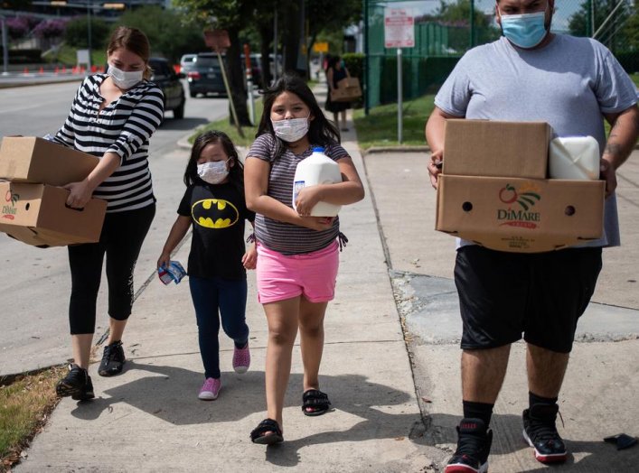 Members of the Rodriguez family carry groceries distributed by the Houston Food Bank for residents affected by the economic fallout caused by the coronavirus disease (COVID-19) pandemic in Houston, Texas, U.S., July 18, 2020. REUTERS/Adrees Latif