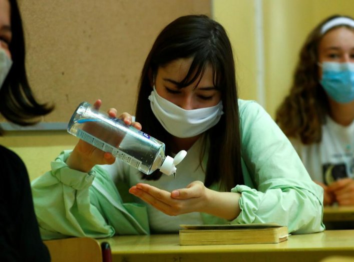 A pupil of the protestant high school "Zum Grauen Kloster" disinfects her hands during a lesson on the first day after the summer holidays, amid the coronavirus disease (COVID-19) pandemic, in Berlin, Germany, August 10, 2020. REUTERS/Fabrizio Bensch