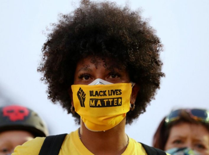 A protester with the "Black Lives Matter" slogan printed on her face mask joins a protest against racial inequality and police violence in Portland, Oregon, U.S., July 26, 2020. REUTERS/Caitlin Ochs