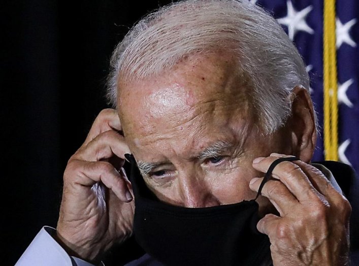 Democratic U.S.presidential candidate Joe Biden adjusts his protective face mask as he calls for the mandatory wearing of masks while speaking to reporters following a briefing on the coronavirus disease (COVID-19) pandemic with public health experts duri