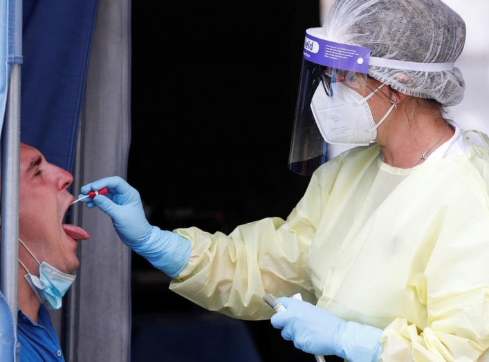 A healthcare worker takes a swab sample from a man at a coronavirus disease (COVID-19) test centre at Rome's San Giovanni hospital in Rome, Italy, August 18, 2020. REUTERS/Remo Casilli