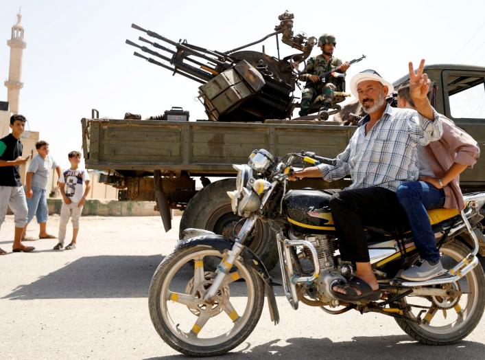 A man gestures as he rides a motorbike in Deraa, Syria, July 4, 2018. REUTERS/Omar Sanadiki