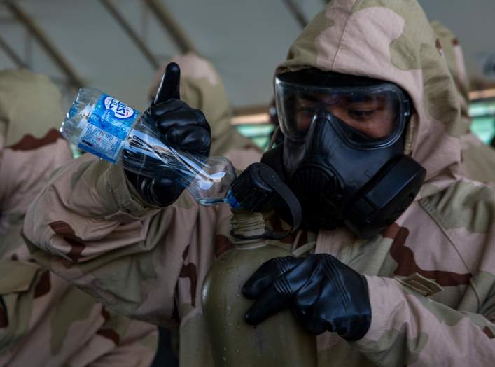 U.S. Marine Corps Cpl. Anthony Calderon, a systems administrator attached to Special Purpose Marine Air Ground Task Force Crisis Response-Central Command, fills his canteen during chemical, biological, radiological and nuclear defense training in Kuwait, 