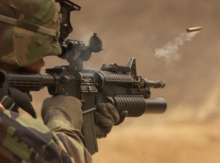 A shell casing flies out with a trail of smoke as U.S. Army Pfc. Michael Freise fires an M-4 rifle during a reflex firing exercise at the Rodriguez Live Fire Complex, Republic of Korea, on March 23, 2005.