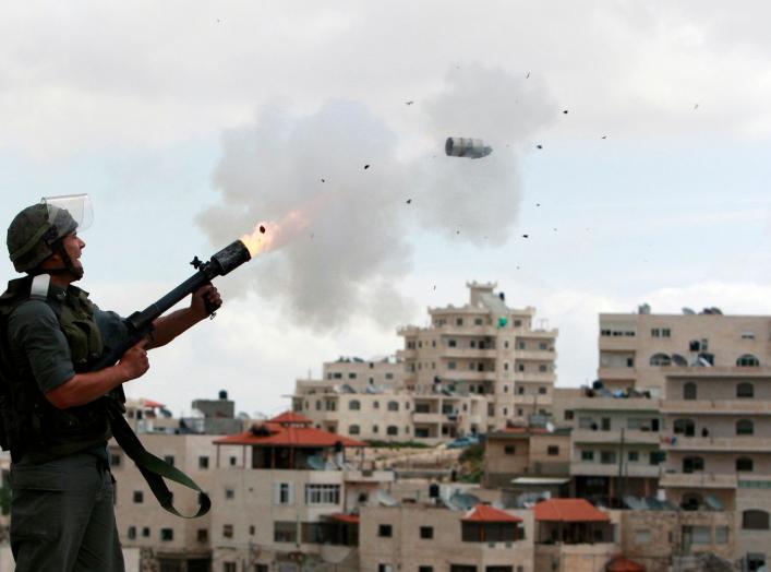 An Israeli border police officer fires tear gas towards Palestinian stone-throwers in East Jerusalem neighbourhood of Issawiya March 16, 2010. Dozens of Palestinian stone-throwers clashed with Israeli police in East Jerusalem on Tuesday on a "day of rage"