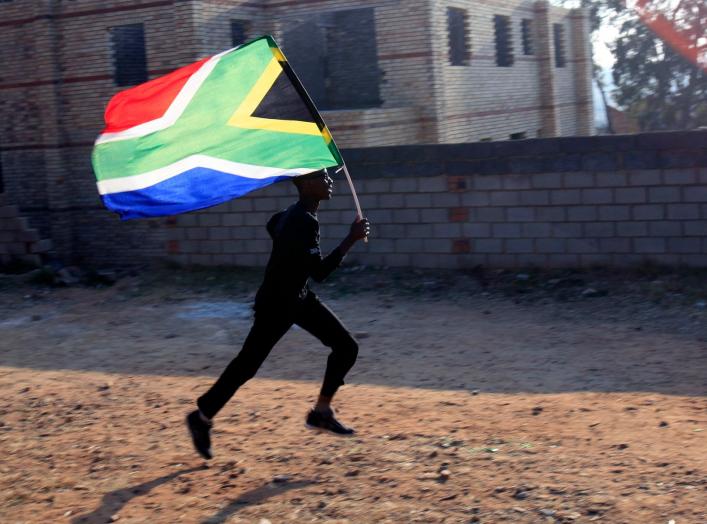 A worker runs with the South African flag inside the Soccer City stadium in Soweto, Johannesburg June 10, 2010. The stadium will host the opening and final games of the 2010 FIFA Soccer World Cup which kicks off on June 11. REUTERS/Radu Sigheti (SOUTH AFR