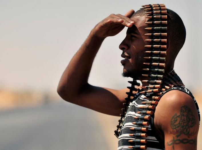 A Libyan rebel stands guard near the entrance of Ras Lanuf August 27, 2011. REUTERS/Esam Al-Fetori (LIBYA - Tags: POLITICS CIVIL UNREST TPX IMAGES OF THE DAY CONFLICT)