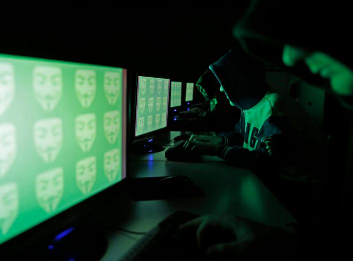 People pose in front of a display showing the word 'cyber' in binary code, in this picture illustration taken in Zenica December 27, 2014. Picture taken December 27, 2014. REUTERS/Dado Ruvic (BOSNIA AND HERZEGOVINA)