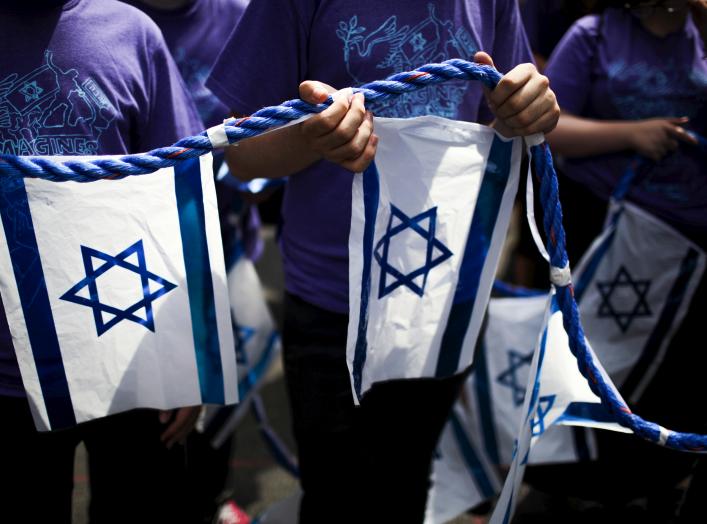 People hold a rope with Israeli national flags attached to it during the 51st annual Israel parade in Manhattan, New York May 31, 2015. REUTERS/Eduardo Munoz 