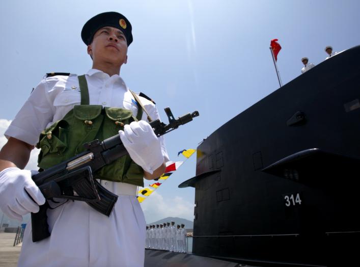 A Chinese Naval officer stands guard beside a submarine at the Ngong Shuen Chau Naval Base in Hong Kong April 30, 2004. China will expand the membership of the military's top decision-making body to "suit the needs of modern warfare" if Taiwan declares in