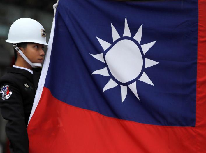 A military honour guard holds a Taiwanese national flag as he attending flag-raising ceremony at Chiang Kai-shek Memorial Hall, in Taipei, Taiwan March 16, 2018. REUTERS/Tyrone Siu