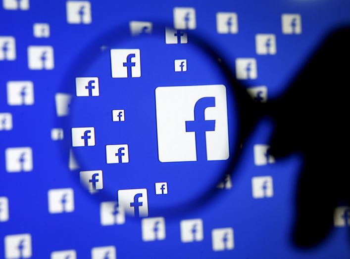 FILE PHOTO: A man poses with a magnifier in front of a Facebook logo on display in this illustration taken in Sarajevo, Bosnia and Herzegovina, December 16, 2015. REUTERS/Dado Ruvic/File Photo