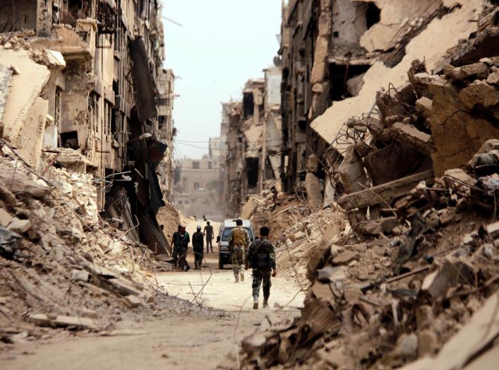 FILE PHOTO: Soldiers walk past damaged buildings in the Yarmouk Palestinian camp in Damascus, Syria May 22, 2018. REUTERS/Omar Sanadiki - RC18889192B0/File Photo