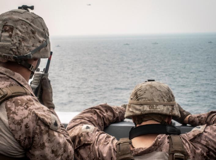 Marines onboard the amphibious transport dock ship USS John P. Murtha (LPD 26) watch nearby Iranian fast inland attack craft, as it transits the Strait of Hormuz, off Oman, in this undated handout picture released by U.S. Navy on August 12, 2019.