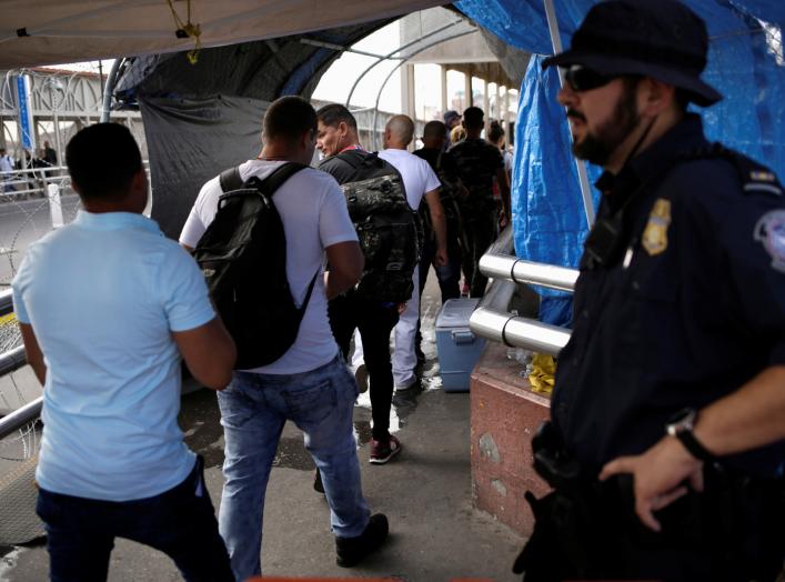 A U.S. Customs and Border Protection (CBP) agent looks at Cuban migrants entering into the United States to claim asylum, at the Santa Fe border crossing bridge in Ciudad Juarez, Mexico September 9, 2019. REUTERS/Jose Luis Gonzalez