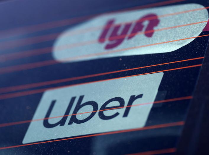 FILE PHOTO: Uber and Lyft signs are seen on a car in Redondo Beach, California, U.S., March 25, 2019. REUTERS/Lucy Nicholson/File Photo