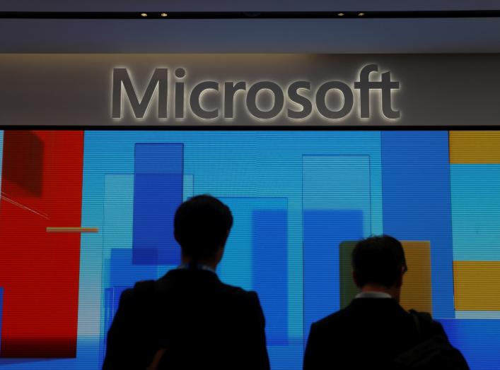 FILE PHOTO: Visitors stand in front of a display screen at Microsoft's new Oxford Circus store ahead of its opening in London, Britain July 9, 2019. REUTERS/Simon Dawson/File Photo