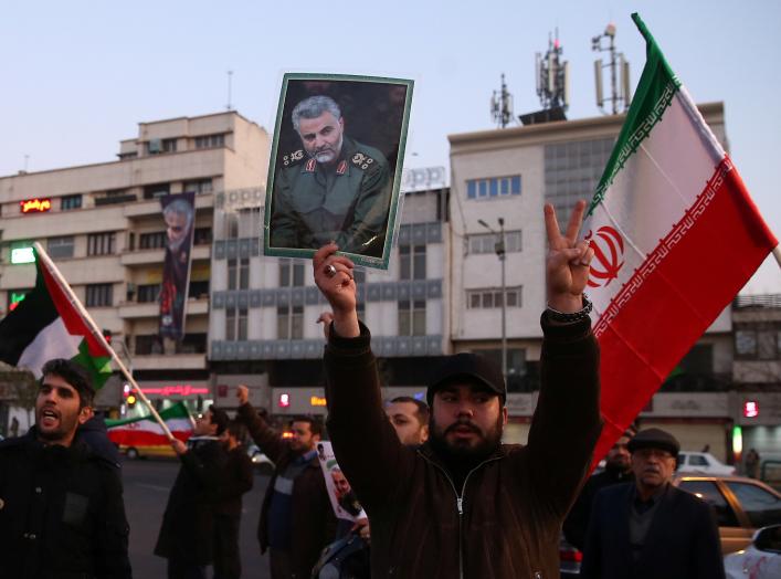 A man holds a picture of late Iranian Major-General Qassem Soleimani, as people celebrate in the street after Iran launched missiles at U.S.-led forces in Iraq, in Tehran, Iran January 8, 2020. Nazanin Tabatabaee/WANA (West Asia News Agency) via REUTERS