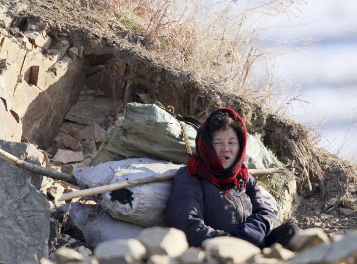 A North Korean woman rests on on the banks of Yalu River, in Sakchu county, North Korea, January 7, 2016. REUTERS/Jacky Chen