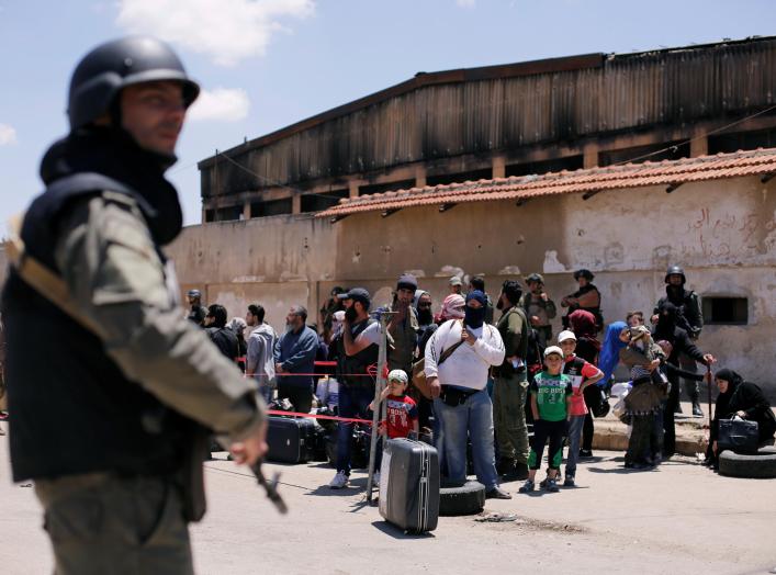 A Syrian security personnel stands guard as rebel fighters and their families evacuate the besieged Waer district in the central Syrian city of Homs, after an agreement reached between rebels and Syria's army, Syria May 21, 2017.