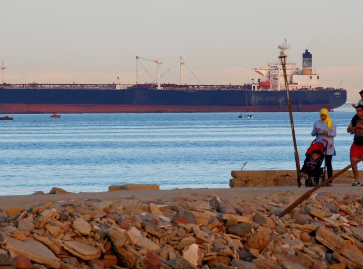 People walk on the beach as a container ship crosses the Gulf of Suez towards the Red Sea before entering the Suez Canal, in El Ain El Sokhna in Suez, east of Cairo, Egypt April 24, 2017. Picture taken April 24, 2017. REUTERS/Amr Abdallah Dalsh