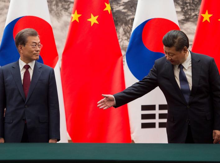 Chinese President Xi Jinping (R) gestures towards South Korean President Moon Jae-In (L) during a signing ceremony at the Great Hall of the People in Beijing, China December 14, 2017. REUTERS/Nicolas Asfouri/Pool