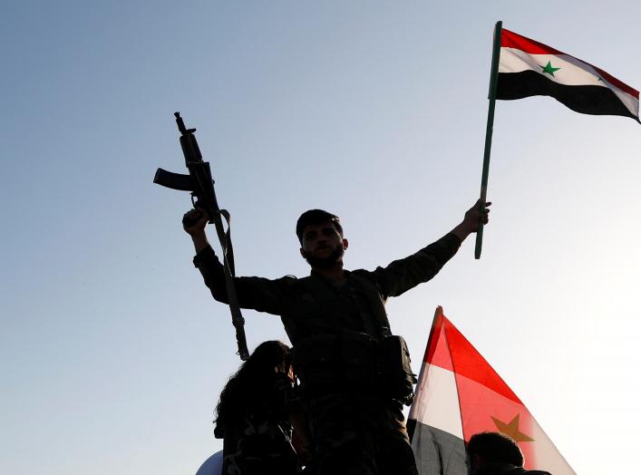 A Syrian soldier waves a flag during a protest against air strikes in Damascus,Syria April 14,2018.REUTERS/ Omar Sanadiki